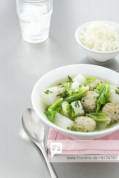 Bowl of Dumpling Soup with Side of Rice and Glass of Water  Studio Shot