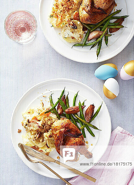 Two plates with cornish hens  scallop potatoes and green beans for Easter dinner