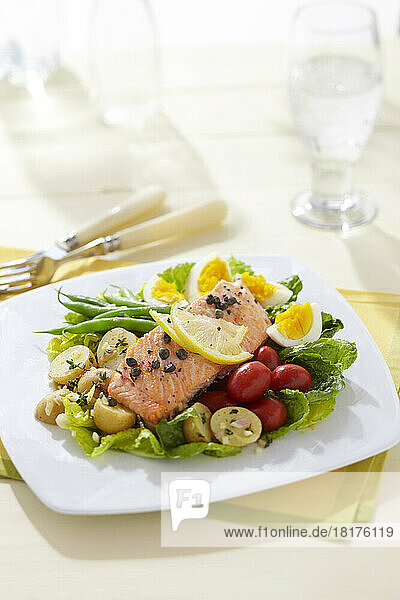 Salmon Nicoise salad with green beans  egg  potatoes  cherry tomatoes on a bed of letttuce