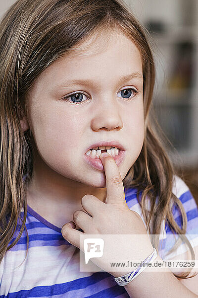 Close-up of Girl Touching space for her Missing Tooth