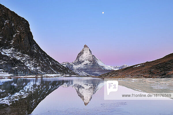 Matterhorn reflected in Lake Riffelsee at Dawn with Moon  Zermatt  Alps  Valais  Switzerland