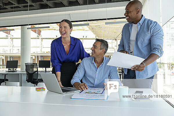 Business colleagues laughing in meeting at office