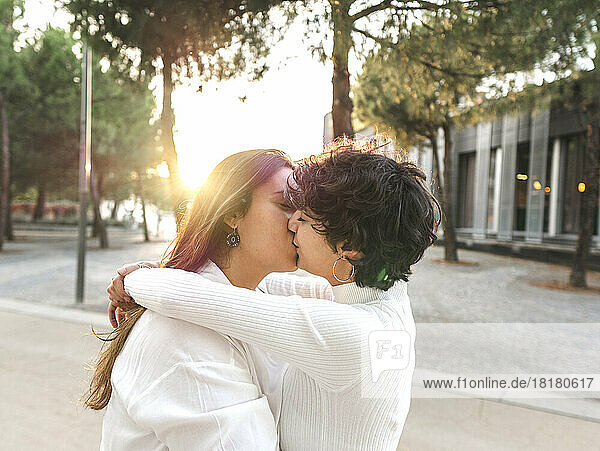 Liebevolles lesbisches Paar  das sich auf der Straße umarmt und küsst
