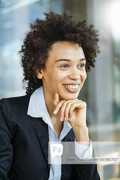 Happy businesswoman with hand on chin
