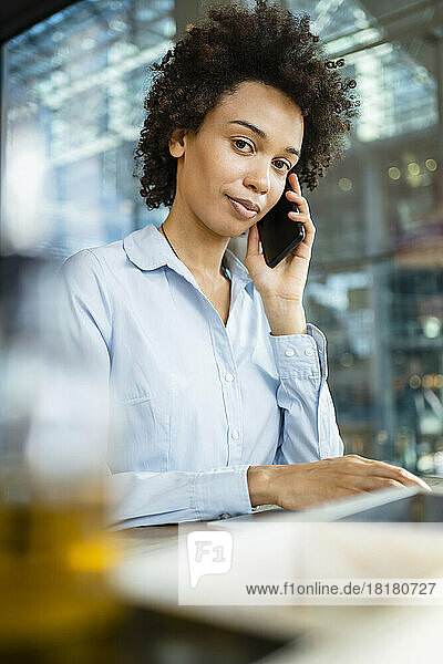Geschäftsfrau telefoniert im Büro mit dem Mobiltelefon