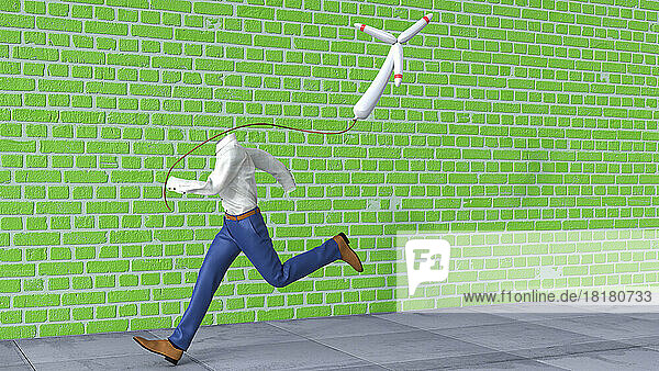 Invisible person running along green brick wall with wind turbine shaped balloon in hand