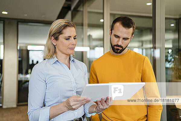 Engagierte Geschäftskollegen teilen sich im Büro ein Tablet