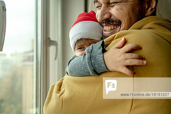 Glücklicher Vater und Sohn umarmen sich zu Hause
