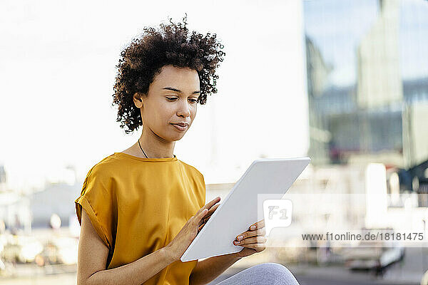 Businesswoman with curly hair using tablet PC