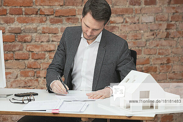 Architekt prüft Papierkram am Schreibtisch am Arbeitsplatz