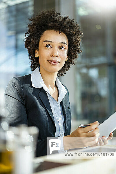 Businesswoman with curly hair holding document