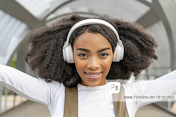 Woman with curly hair wearing bluetooth headphones