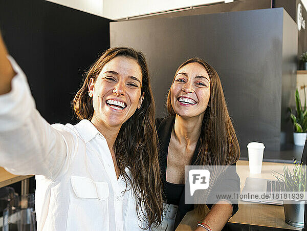 Happy businesswomen talking selfie in office