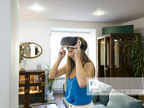 Happy young woman wearing VR goggles