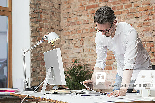 Geschäftsmann nutzt Tablet-PC am Schreibtisch im Büro