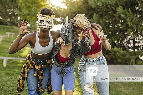 Happy women wearing animal mask having fun at park