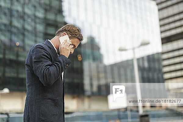 Businessman talking through mobile phone outside building