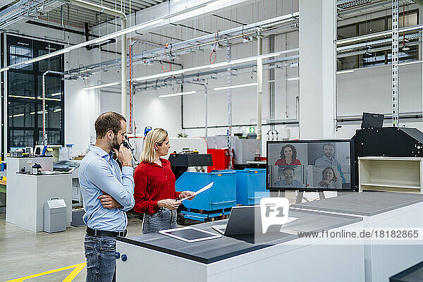 Business colleagues doing video conference on computer screen in factory