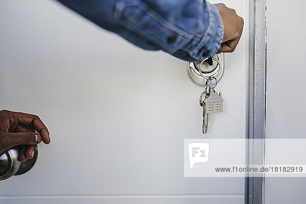 Hand of woman opening door with house keys