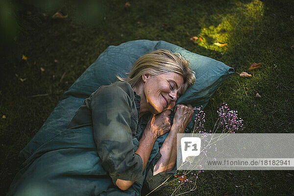 Smiling mature woman sleeping in garden
