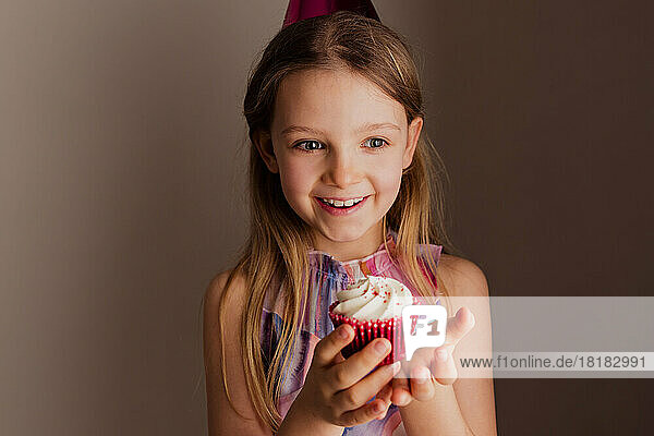 Portrait of happy little girl with cup cake