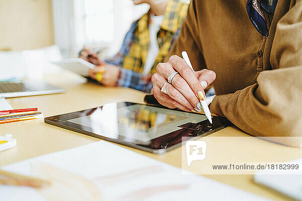 Graphic designer with digitized pen using tablet PC at desk