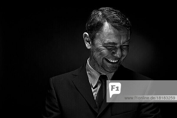 Mature man smiling against black background