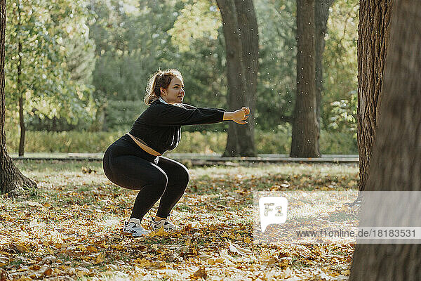 Young woman squatting in park