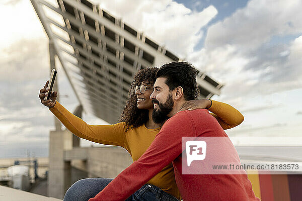 Happy young couple taking selfie through smart phone