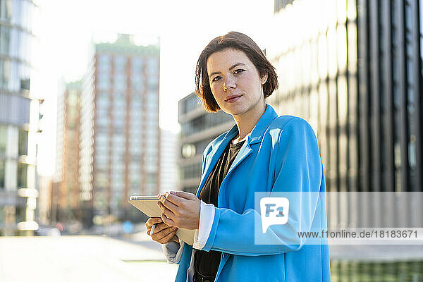 Young businesswoman wearing blue blazer holding tablet PC