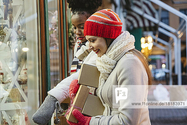 Excited women doing window shopping at Christmas festival