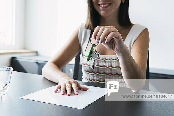 Real estate agent holding house keys in office