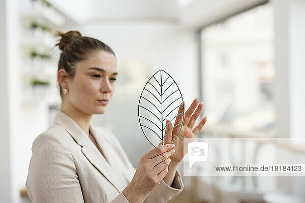 Businesswoman analyzing leaf shape model in office