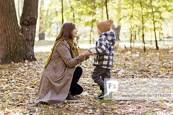 Smiling mother and son playing in park