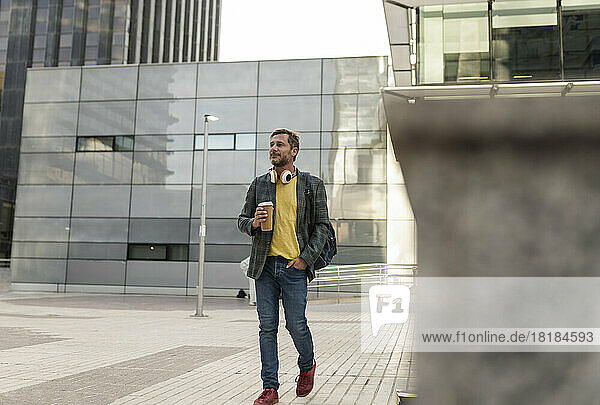 Man walking with coffee cup in city