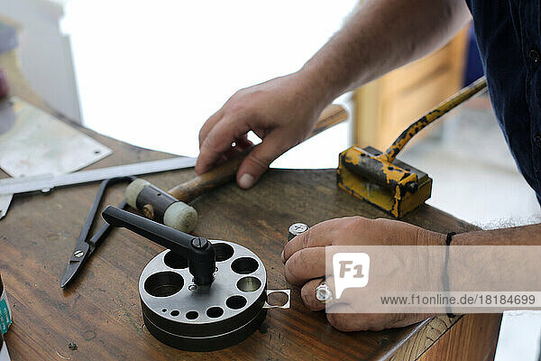 Schmuckkünstler benutzt Werkzeug auf Werkbank in der Werkstatt