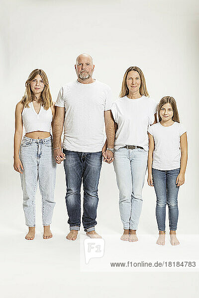 Mother and father with daughters against white background