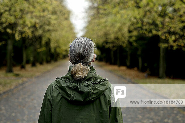 Senior woman with gray hair wearing hooded raincoat