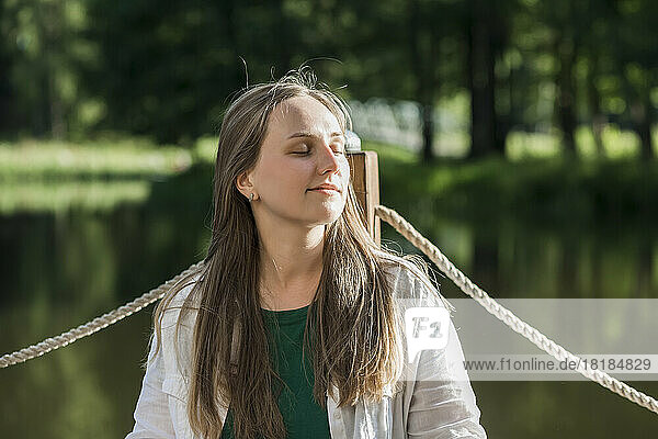 Smiling young woman leaning on railing