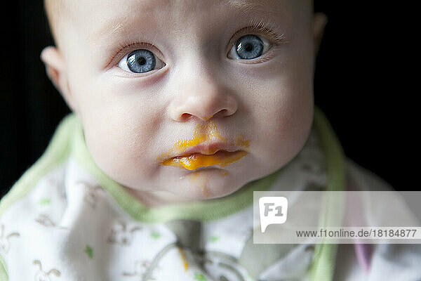 Portrait of baby boy against black background  close up