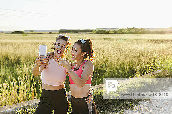 Happy woman with instructor taking selfie on footpath