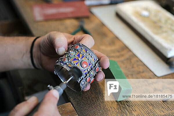 Hands of jeweller polishing bangle in workshop