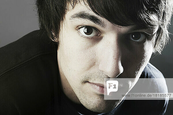 Portrait of young man against grey background  close up
