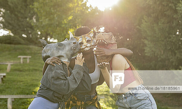 Fröhliche junge Frauen mit Tiermaske haben Spaß im Park
