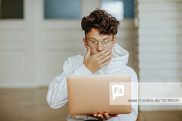 Surprised boy looking at laptop