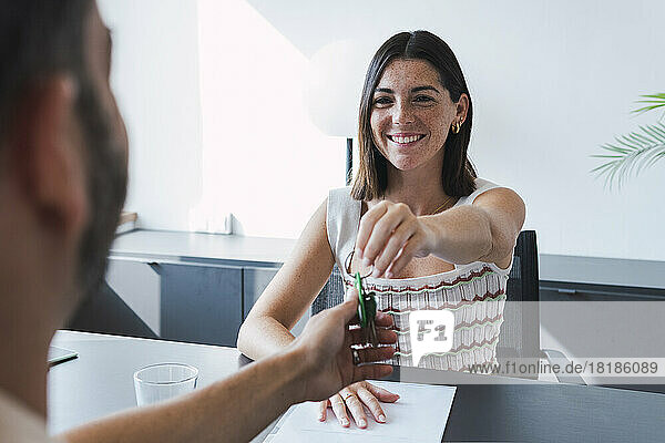 Happy real estate agent offering keys to customer