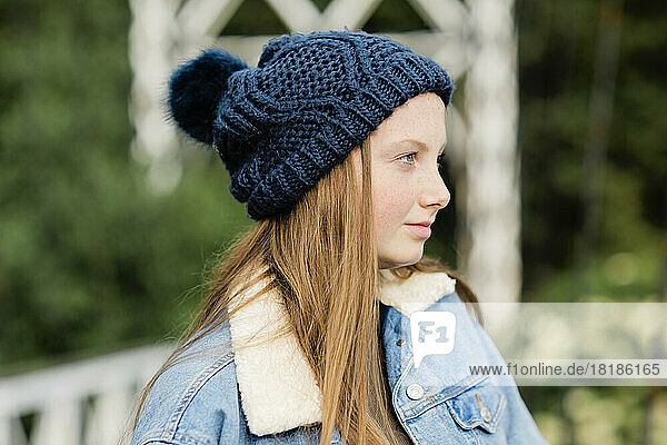 Portrait of teenage girl wearing woolly hat  looking sideways