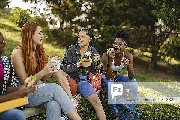 Glückliche Freunde essen Snack im Park