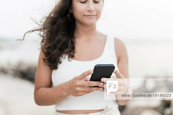 Young woman using smart phone at beach