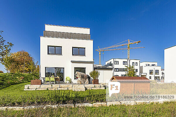 Germany  Baden-Wurttemberg  Weinstadt  Back yard of modern suburban house with industrial crane in background
